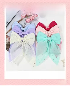 Détail de barrettes nœuds en maille multicolore avec strass aux tons pastels