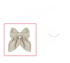 Détail de la pince à cheveux avec nœud en satin champagne et texture soyeuse élégante