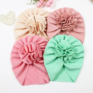 Soft ribbed baby turban hats with large fabric flowers in pastel colors