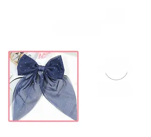 Détail de la pince à cheveux noeud bleu marine avec strass et rubans élégants