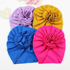 Four-pack of infant turban hats with pleated flowers in purple, yellow, blue, and rose pink