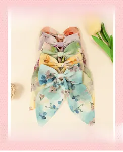 Détail de cinq barrettes à nœuds en mousseline florale avec de longs rubans élégants