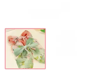 Détail de barrettes noeud en mousseline florale en rose pastel et vert tendre