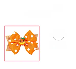 Détail de pince à cheveux Halloween avec ruban orange à pois et décor citrouille