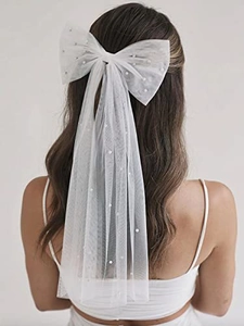 Detalle del lazo de tul blanco para novia con perlas en el clip de pelo con velo largo de malla