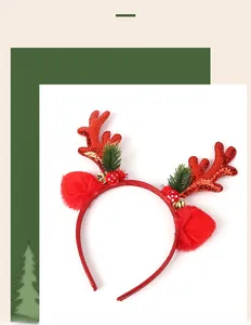 Detail of red Christmas reindeer antler headband with sequins, green pine needles and golden bells