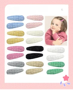 Detail of colorful textured fabric snap hair clips and kid model wearing styling