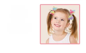 Detail view of colorful glitter bow hair clips for kids on a girl's pigtails