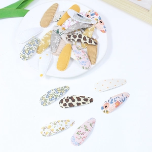 Floral and leopard print fabric covered teardrop hair clips set on a white plate