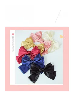 Detailed set of six large satin bow hair clips in pink, beige, gold, red, blue, and black