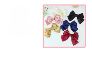 Detail of six satin bow hair clips in cream, black, pink, navy, gold and burgundy