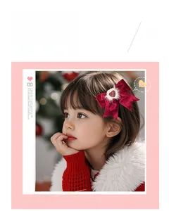 Gros plan d'une barrette nœud en velours rouge avec pompon blanc et petit pendentif cœur