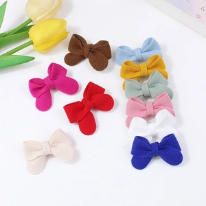 Set of 11 colorful handmade fabric bow hair clips for girls in a flat lay aesthetic view