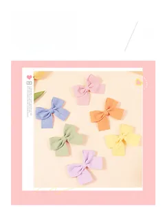 Détail de six barrettes à nœud aux couleurs macaron avec un fini textile texturé