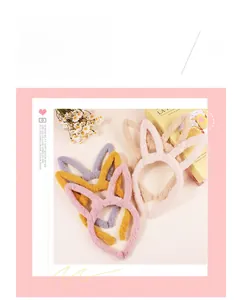 Detail shot of soft plush rabbit ear headbands in various pastel colors on a soft background
