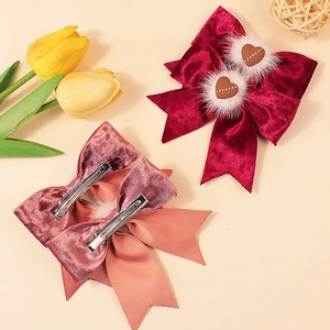 Barrette à nœud en velours bordeaux avec pompons blancs et accents en forme de cœur