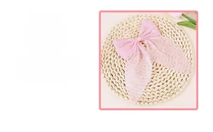 Detailed close-up of pink organza bow accessory with sparkling rhinestone embellishments