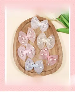 Detail of DIY mesh bow accessories with pearls and sequins in pastel macaron colors
