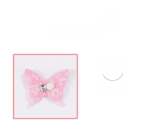Détail d'une pince à cheveux papillon en tissu rose avec motifs floraux et une petite perle