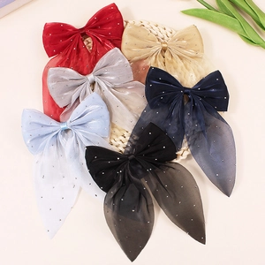 Sparkling mesh bow hair clips in six colors with rhinestones on a woven tray