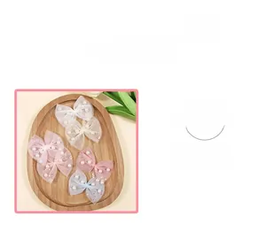 Detailed view of mesh bow hair accessories featuring elegant pearls and shiny sequins