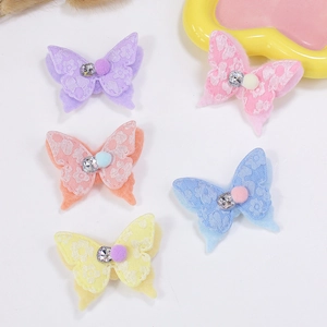 Cinq barrettes papillon colorées avec tissu en dentelle et petites boules de poils