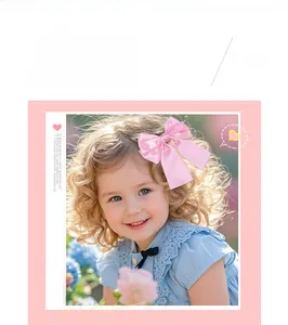 Pink ribbon bow hair clip worn by a girl with blonde curly hair in a garden setting