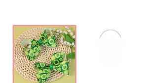 Close-up of green clover patterned ribbon bow hair clips on a woven mat with flowers