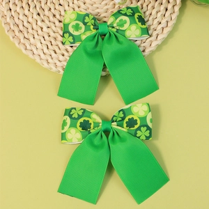 Handmade green grosgrain ribbon bow clips with clover patterns for St. Patrick's Day
