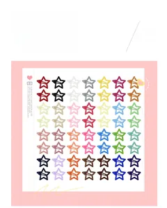 Flat lay of fifty-six colorful star-shaped hair clips organized on a pink dotted board