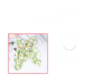 Detail of green bow hair clip with white daisy floral print and soft fabric texture