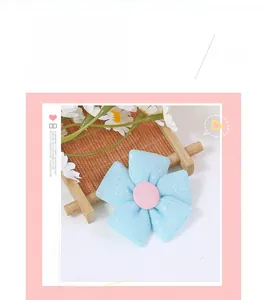 Detail of five-petal blue glitter fabric flower with pink fabric button for DIY accessories