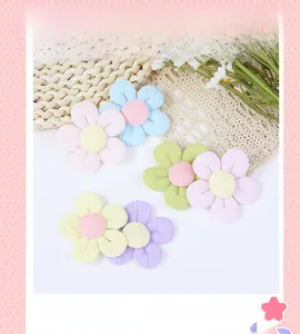 Macro view of colorful fabric flower charms with quilted petals and contrast buttons