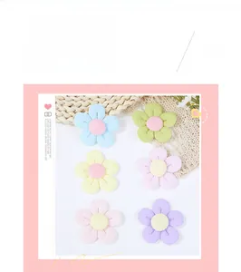 Detailed view of six colorful fabric flower accessories in pastel macaron shades