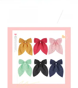Detailed set of six polka dot bow hair clips in multiple vibrant colors and fabric texture