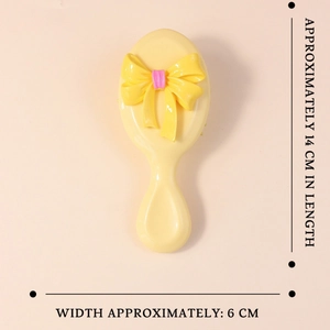 Mini spazzola per capelli gialla con fiocco decorativo e design compatto da viaggio