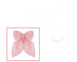 Detail of pink polka dot bow hair clip showing soft fabric texture and sweet pattern design