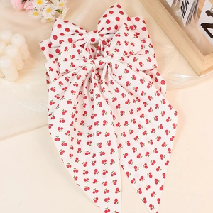 Sweet strawberry and cherry print bow hair clip with long ribbons on a soft beige fabric