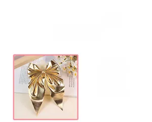 Detailed macro shot of elegant golden metallic bow hair clip with reflective satin finish