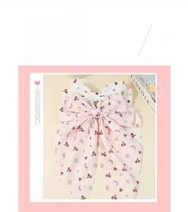 Dettaglio di fermagli per capelli in chiffon con fiocco e stampe di ciliegie per bambine