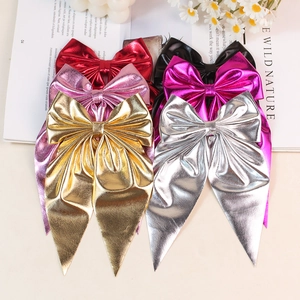 Elegant metallic bow hair clips with long streamers in multiple colors on a fashion magazine
