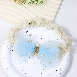 Close-up of baby lace headband with light blue mesh bow and tiny white pearls detail