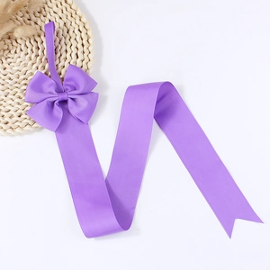 Purple hair bow organizer with ribbed ribbon and dovetail cut on white background