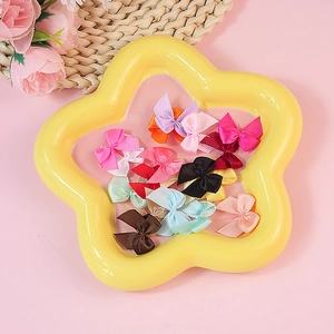 Mini nœuds en ruban de satin colorés pour couture DIY sur un plateau en étoile