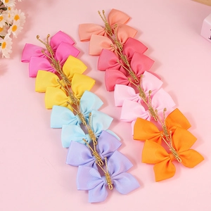 Flat lay of colorful handmade grosgrain ribbon butterfly hair clips in eight pastel colors