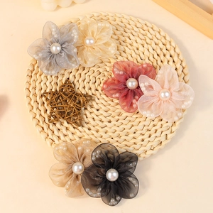 Handmade mesh pearl flower accessories in six elegant colors on a rustic straw tray