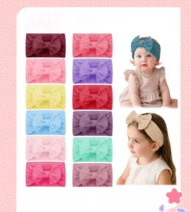 Detail view of 12 colorful soft baby bow headbands featuring elastic ribbed fabric texture