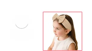 Close-up of soft beige knitted baby headband with large bow detail and ribbed texture