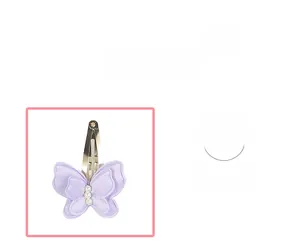 Dettaglio molletta a farfalla in tessuto viola con perle bianche e clip in metallo argento