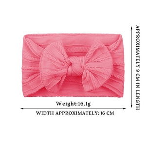 Pink knitted baby headband with large bow and soft elastic cable knit texture details